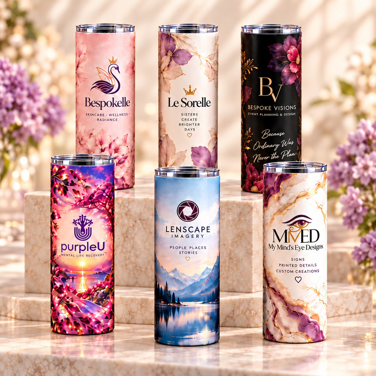 Six custom 20 oz tumblers with Bespokelle, Le Sorelle, Bespoke Visions, purpleU, Lenscape Imagery, and MMED designs arranged on cream stone.